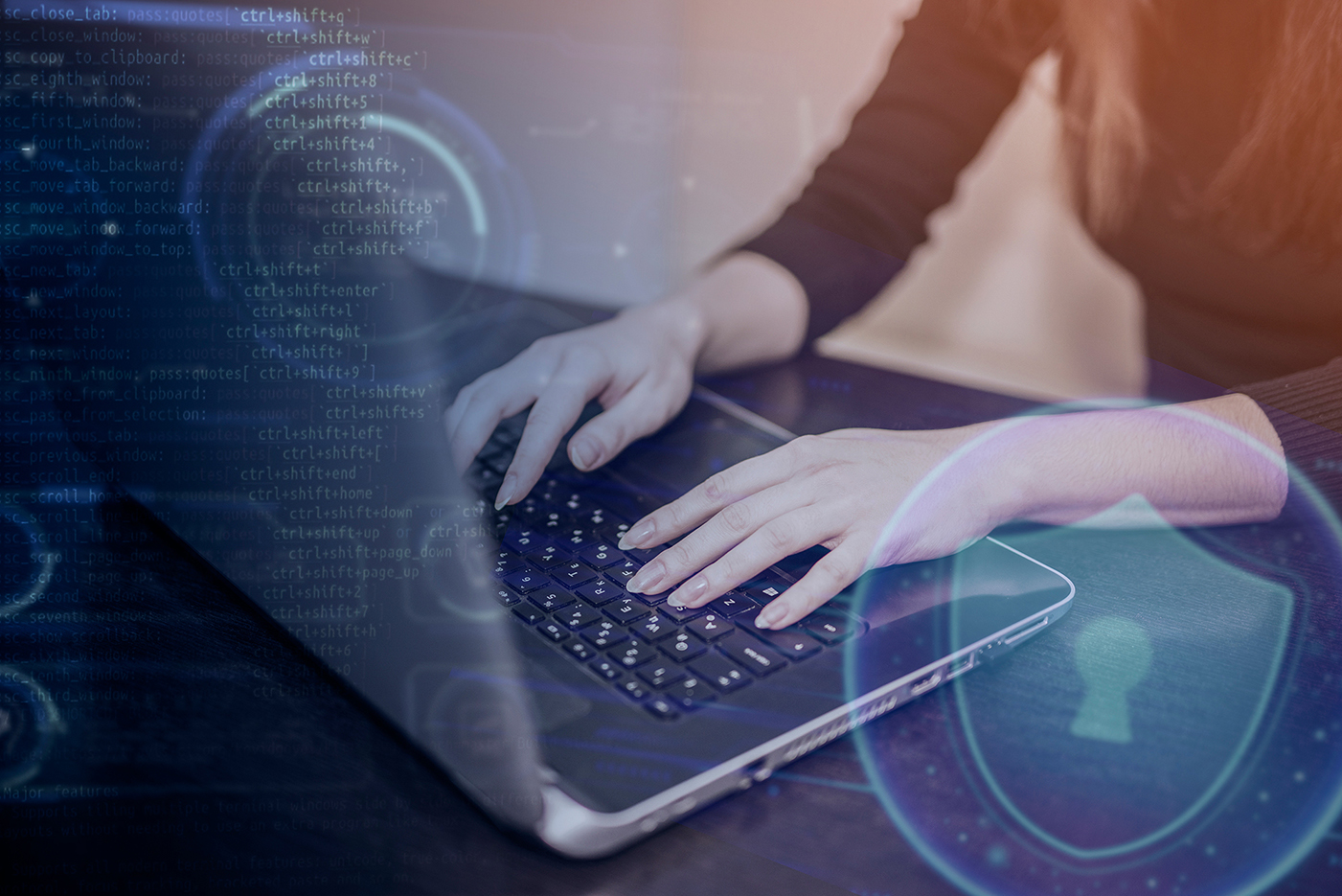 Person working on a laptop with digital security symbols overlayed, representing cybersecurity in a cloud environment.