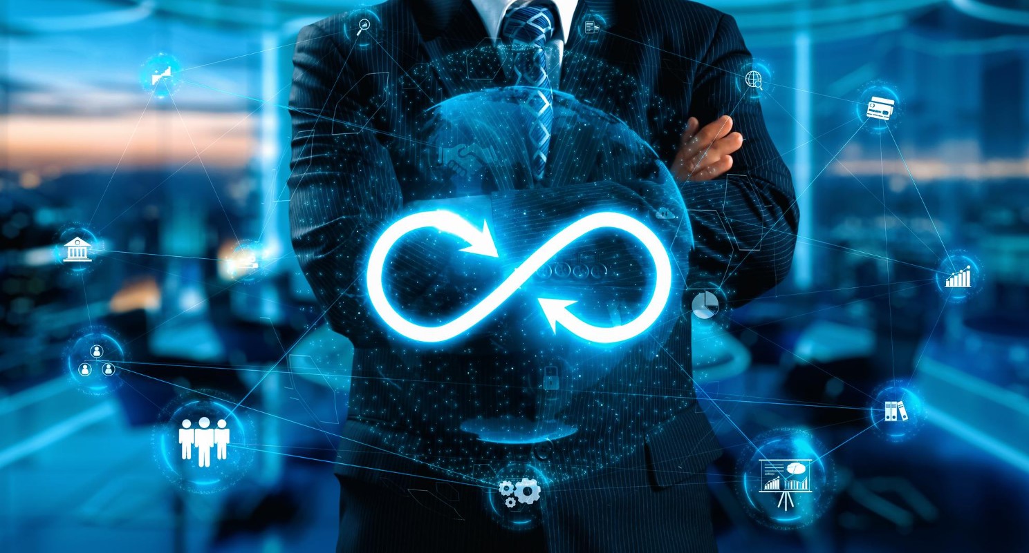 Businessman with DevOps infinity loop and digital icons.