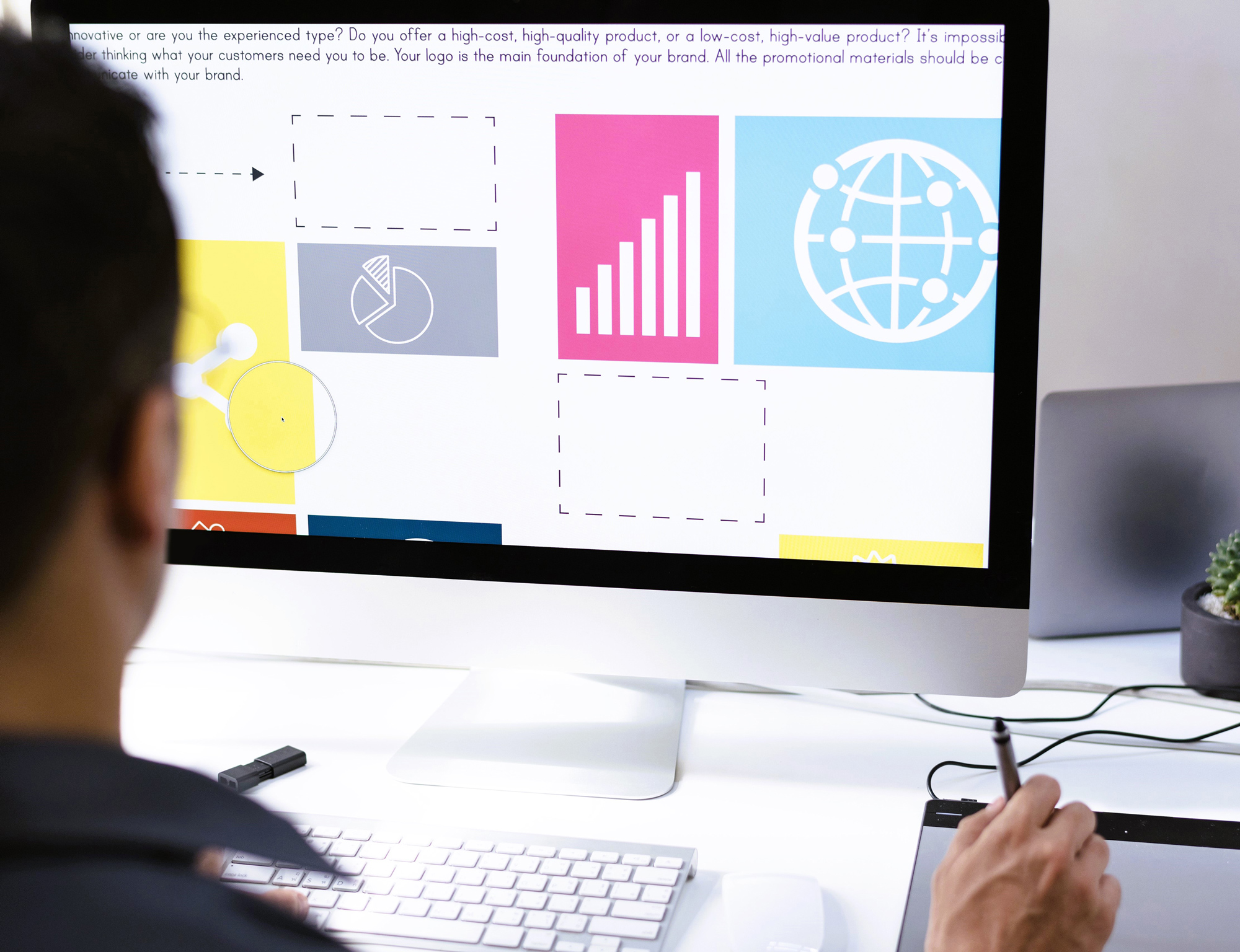 Collaborative team designing website elements on a large computer screen in a modern workspace.