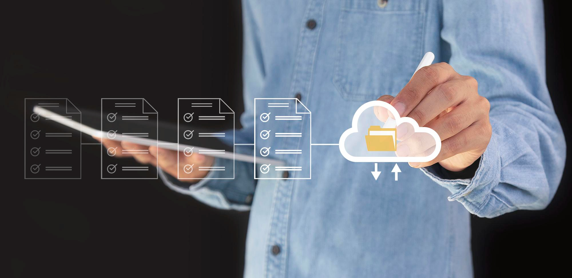 Person using tablet and drawing cloud folder icon over digital project checklists for a cloud project questionnaire.
